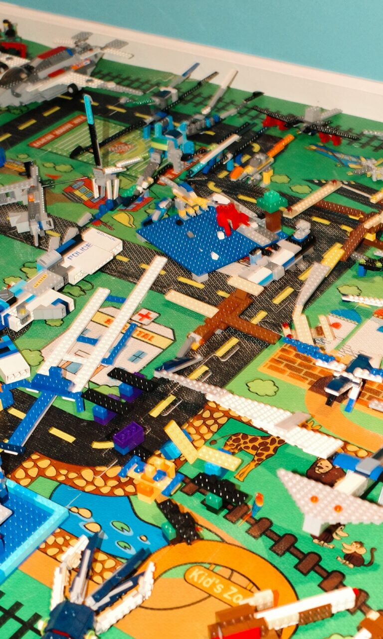 assortment of Lego in various states of assembly on a child's play rug