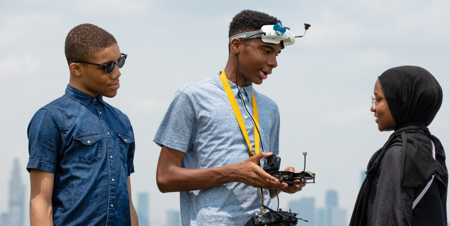 Three Black teen siblings talk. Two are boys and one is a girl in a hijab