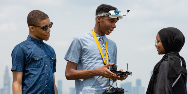 Three Black teen siblings talk. Two are boys and one is a girl in a hijab