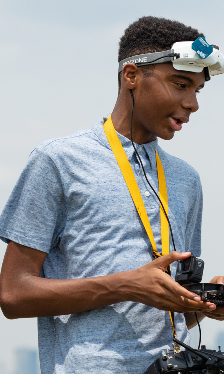 Three Black teen siblings talk. Two are boys and one is a girl in a hijab