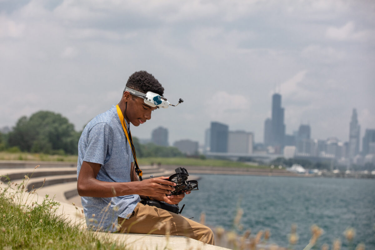 Yusuf sitting lakeside with his drone