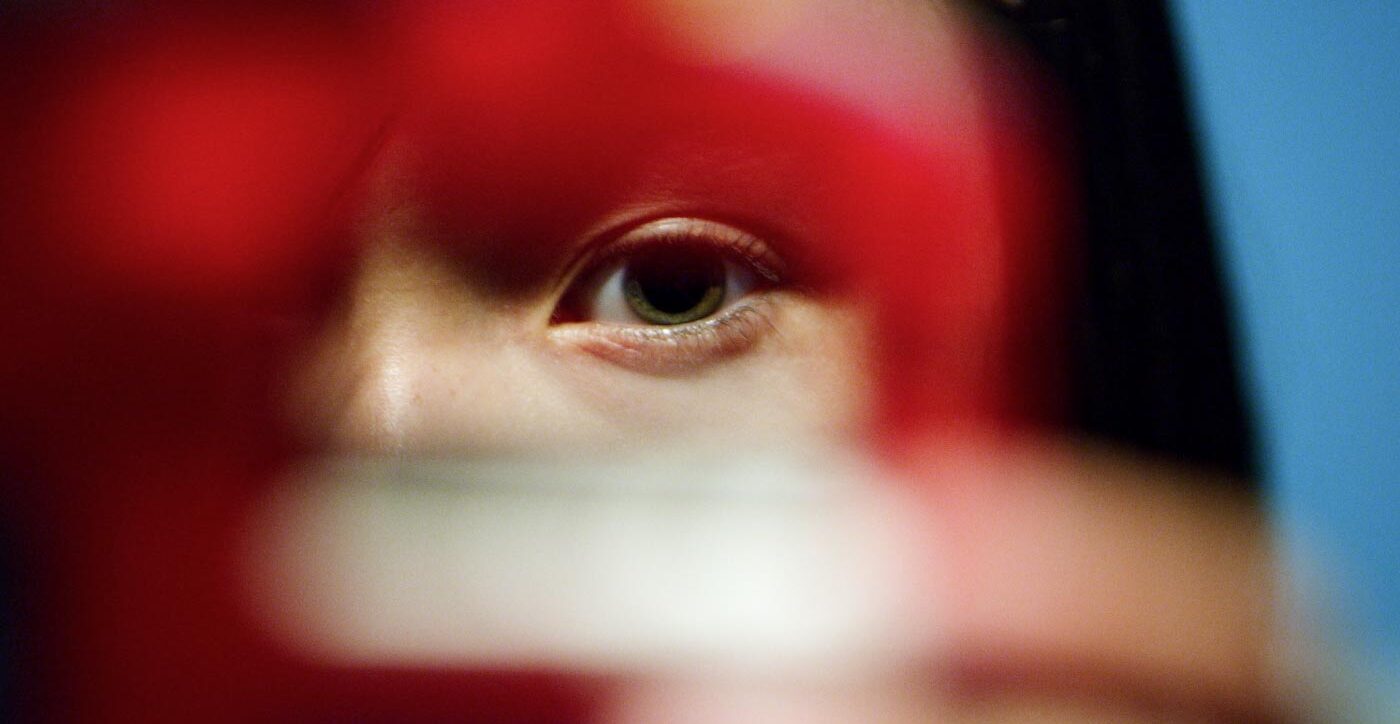 Young person peering through a cookie cutter into the camera lens