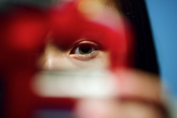 Young person peering through a cookie cutter into the camera lens