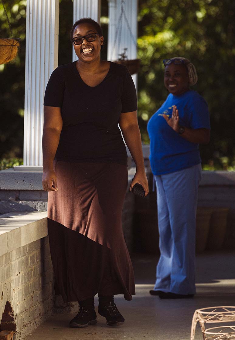 A Black woman laughs as she walks away from her mother
