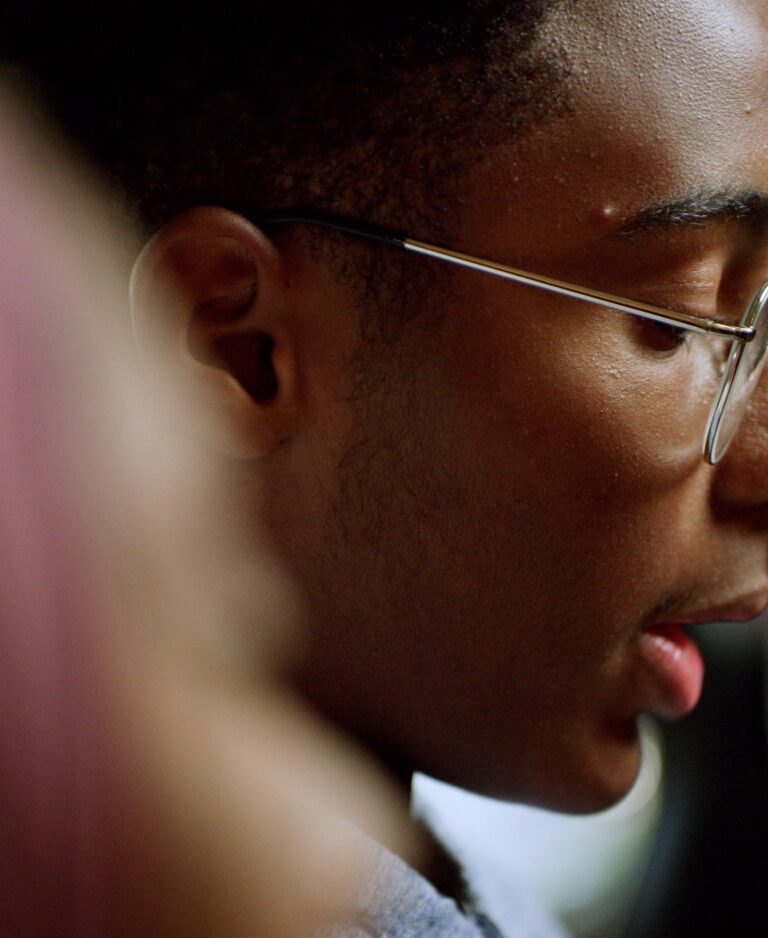 A boy with glasses reads a letter