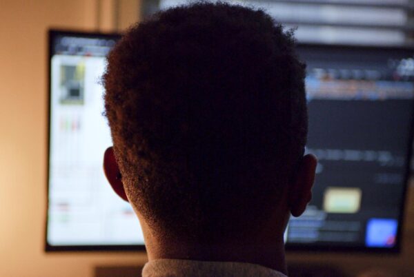 A boy looking at a large computer screen