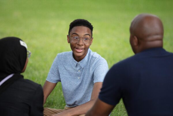 A teenage boy talks to his mom and dad