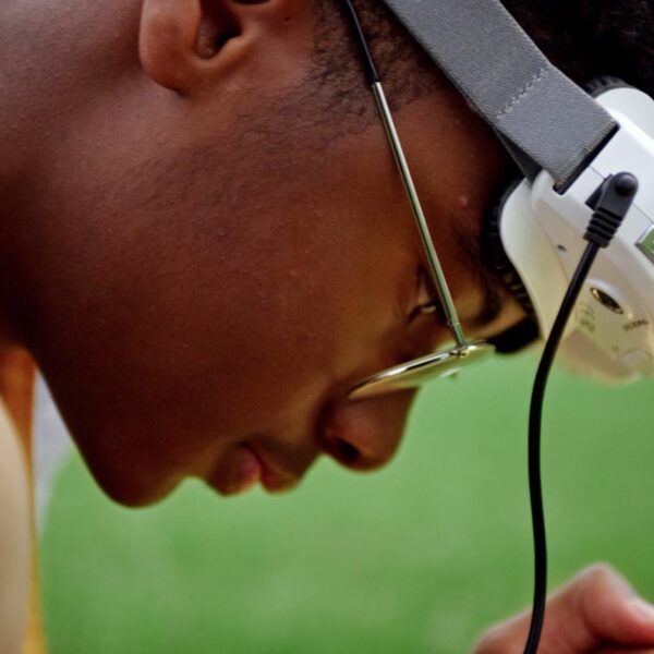 A closeup of Ashley's son Yusef looking at something out of frame in his hands with googles resting on his forehead.