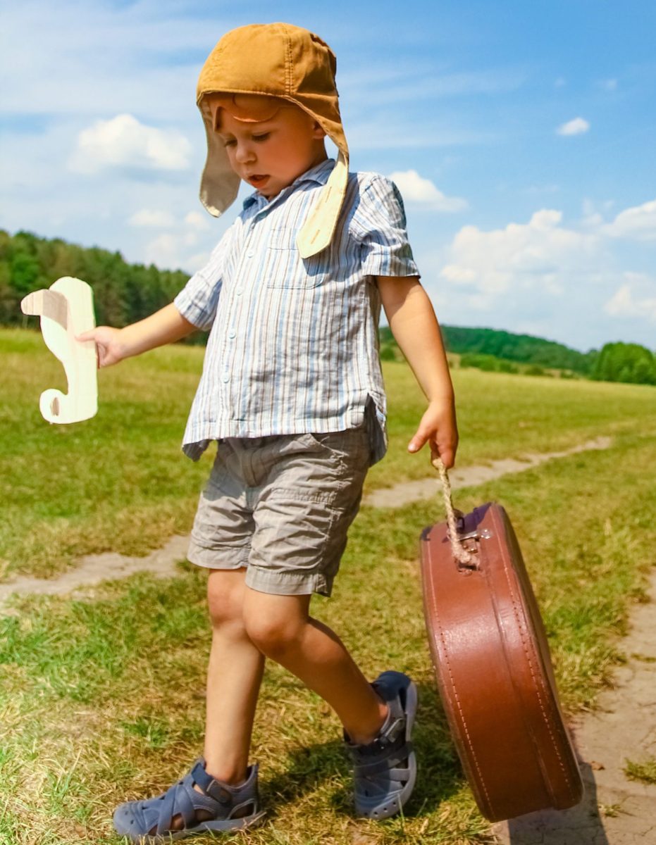 Boy playing with toy plane outside